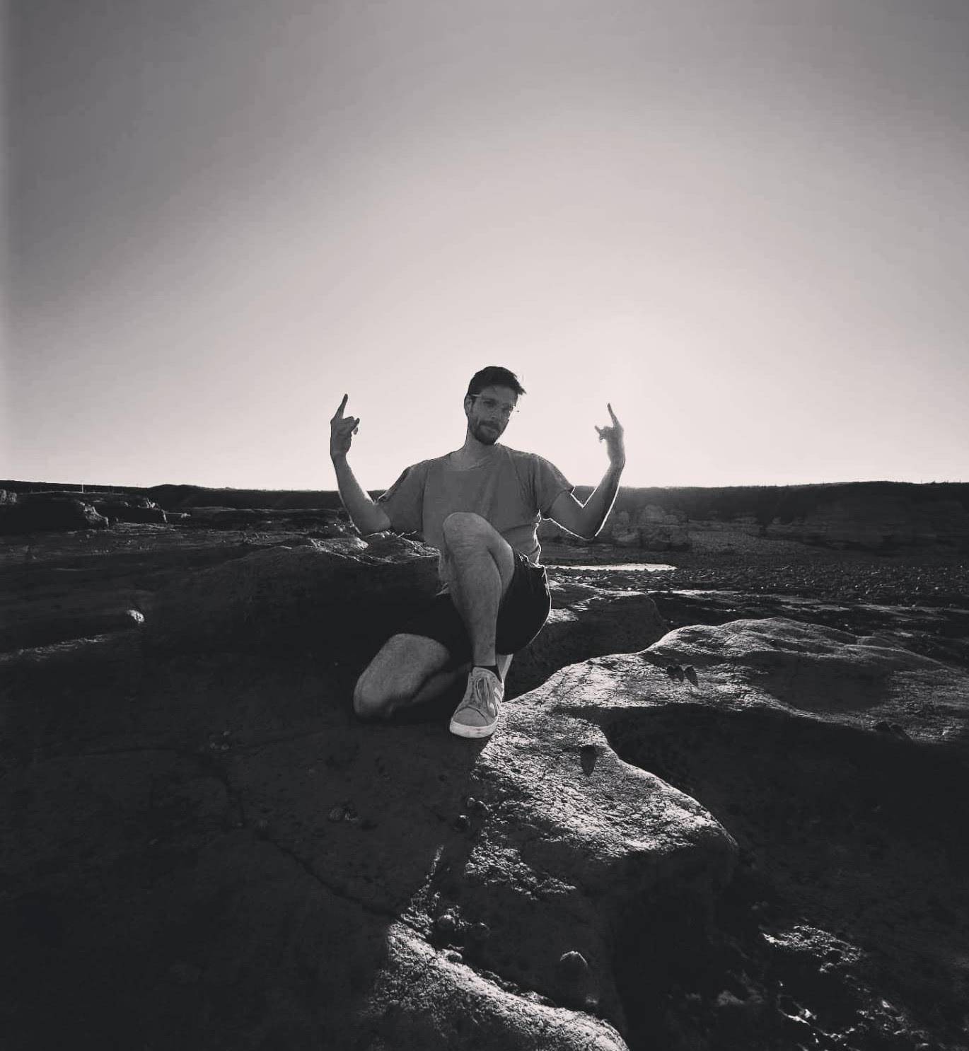 This is a picture of me, Michael Kailas, standing on some rocks on the beach